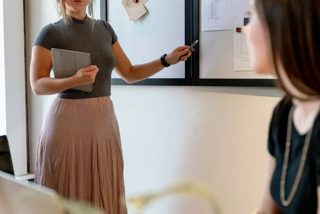 Kvinde holder præsentation i mødelokale som illustration af corporate feminisme og kvinder i arbejdslivet
