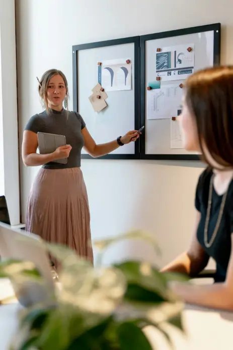 Kvinde holder præsentation i mødelokale som illustration af corporate feminisme og kvinder i arbejdslivet